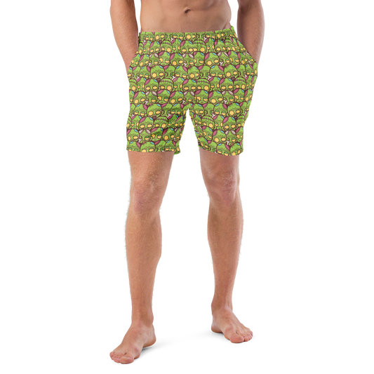 Person wearing green Halloween patterned recycled swim trunks on a white background