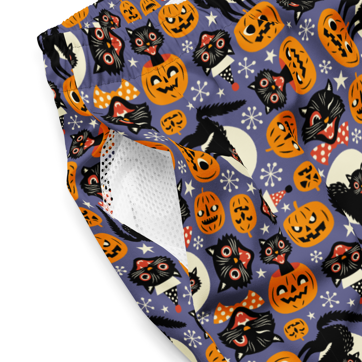 Halloween-themed recycled swim trunks with cats, pumpkins, and ghosts on a purple background close-up