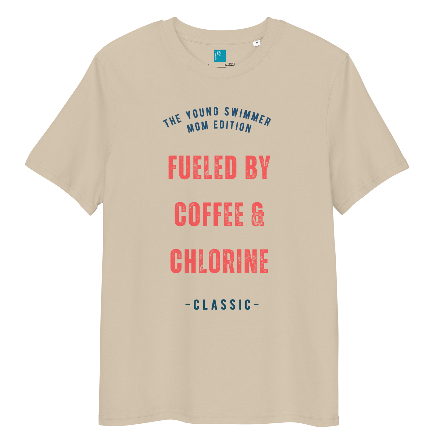 Desert dust organic cotton swim mom t-shirt with red and navy text: “Fueled by Coffee & Chlorine – The Young Swimmer Mom Edition – Classic.”