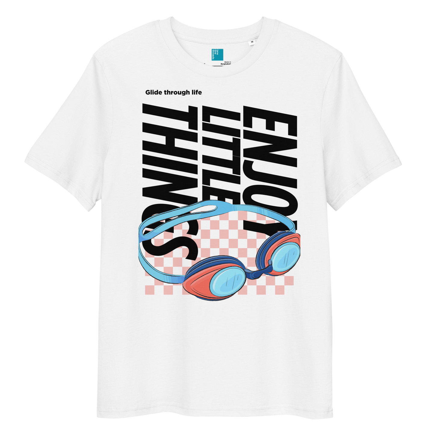White eco-friendly t-shirt featuring vibrant blue and red swimming goggles with a checkered background, and bold black text "ENJOY THE LITTLE THINGS" rotated vertically. Above the goggles, "Glide through life" is in smaller text. Made from 100% organic cotton, this breathable and biodegradable shirt is perfect for competitive swimmers who value comfort, performance, and sustainability. Ideal gift for swim meets or lane-protecting athletes with a sense of humor.
