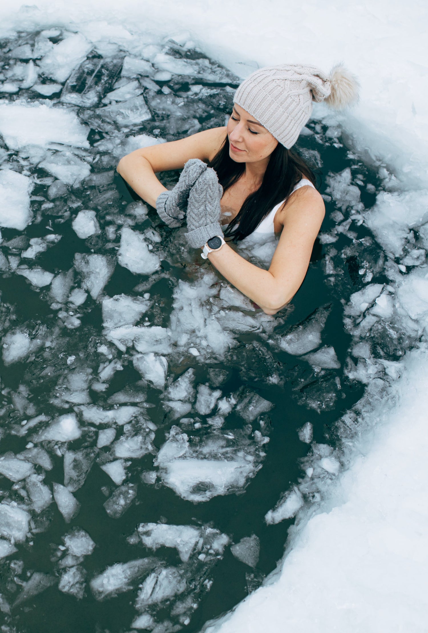 Person in a frozen lake surrounded by ice chunks