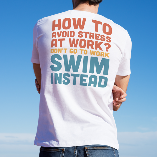 Young man wearing an organic t-shirt with humorous text about avoiding stress at work by swimming, against a clear blue sky.