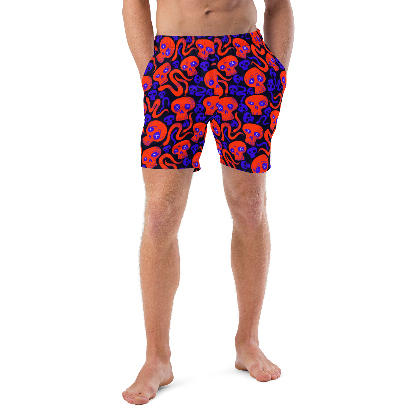 Person wearing Halloween themed organic swim trunks with a skulls and snakes pattern on a white background