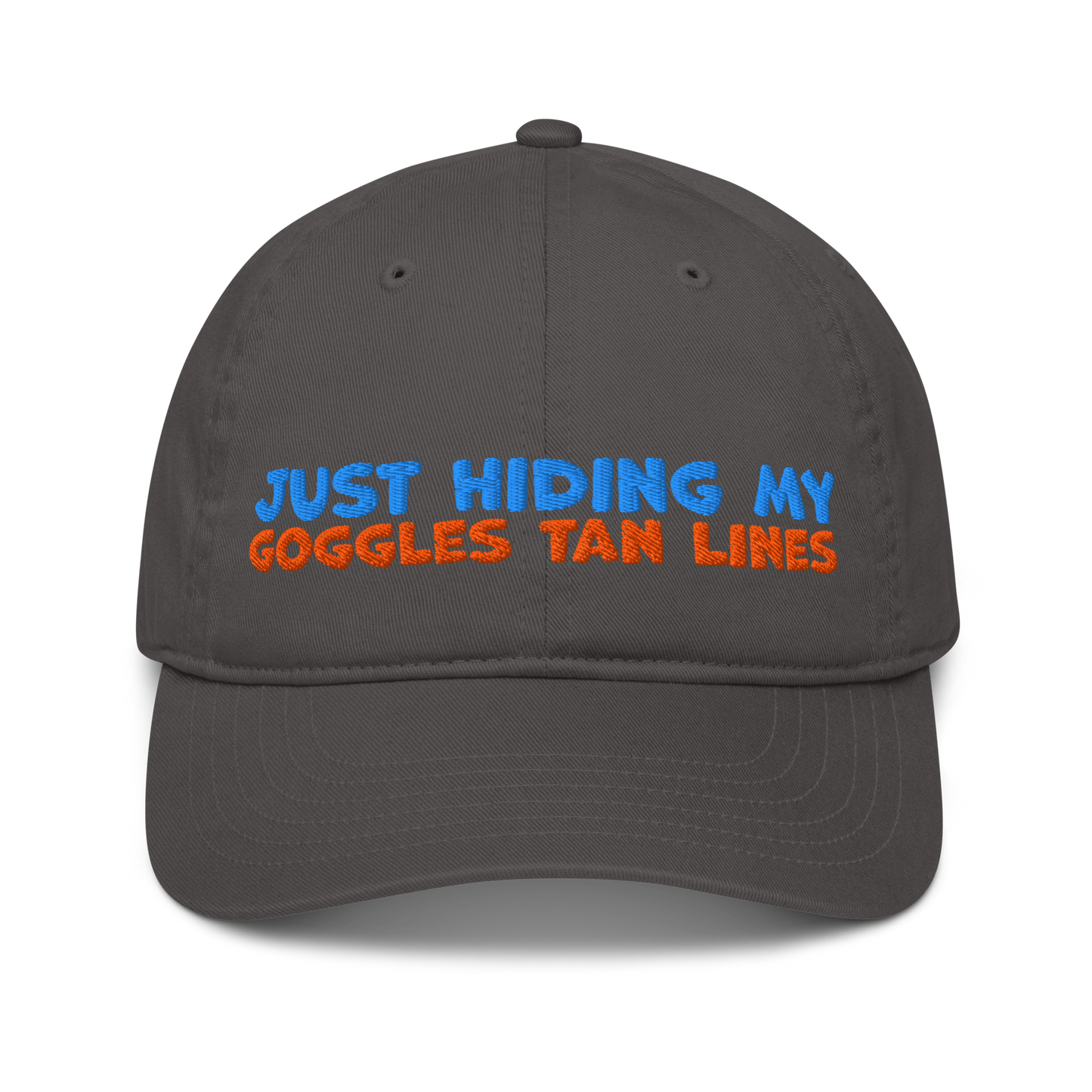 Charcoal organic cotton baseball cap with "JUST HIDING MY GOGGLES TAN LINES" embroidered in blue and orange text.