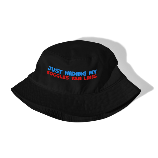 Black bucket hat with text 'Just hiding my goggles tan lines' on a white background