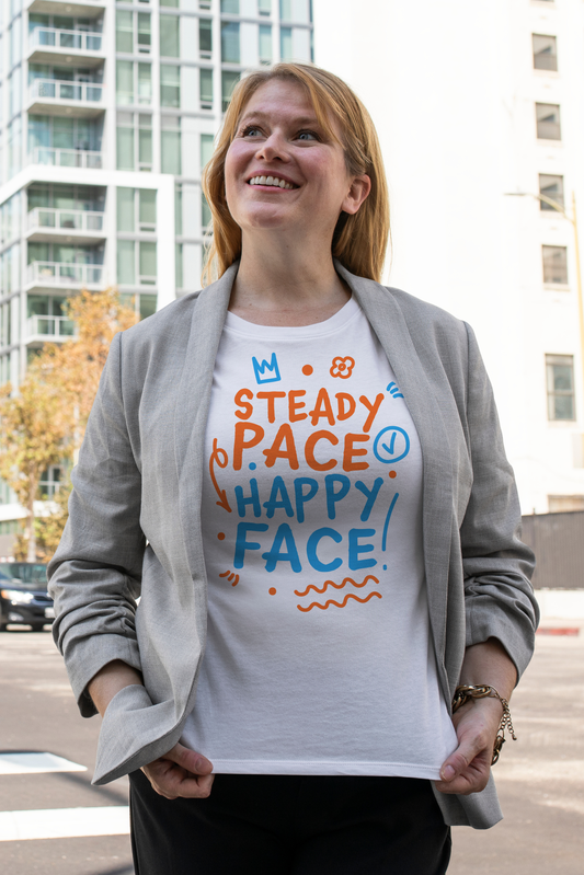 Woman wearing a white organic swim shirt with colorful text in an urban setting