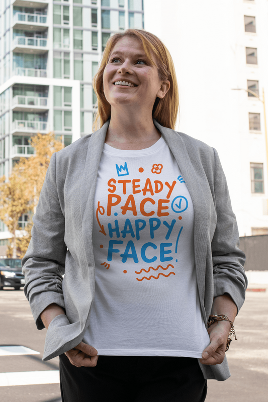 Woman wearing a white post swim organic t-shirt with colorful text in an urban setting