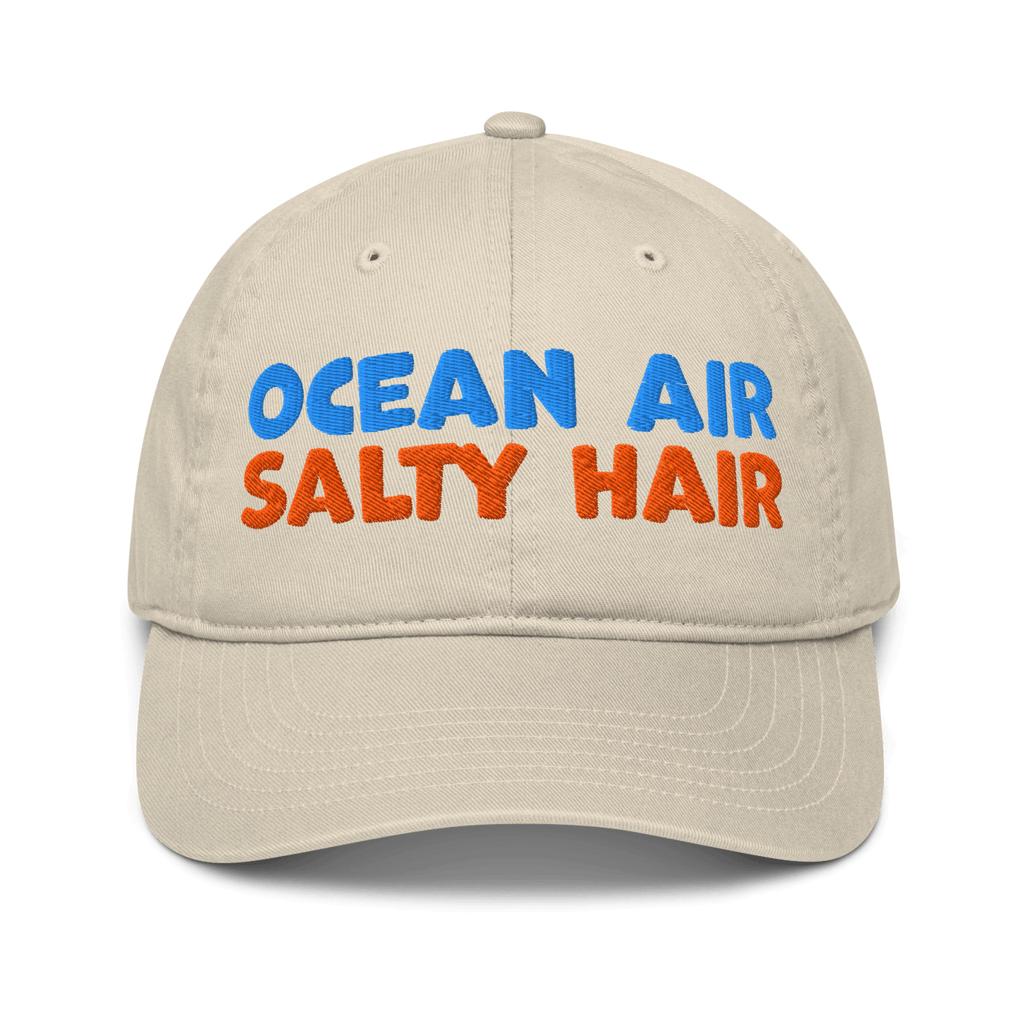Beige organic cotton baseball cap with "OCEAN AIR" in blue and "SALTY HAIR" in orange embroidered text.