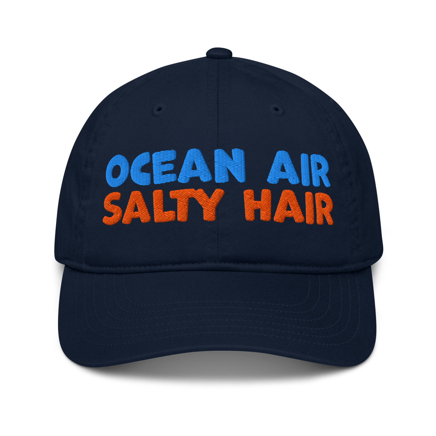 Navy organic cotton baseball cap with "OCEAN AIR" in blue and "SALTY HAIR" in orange embroidered text.