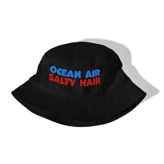 Black bucket hat with 'Ocean Air Salty Hair' text in blue and red on a white background