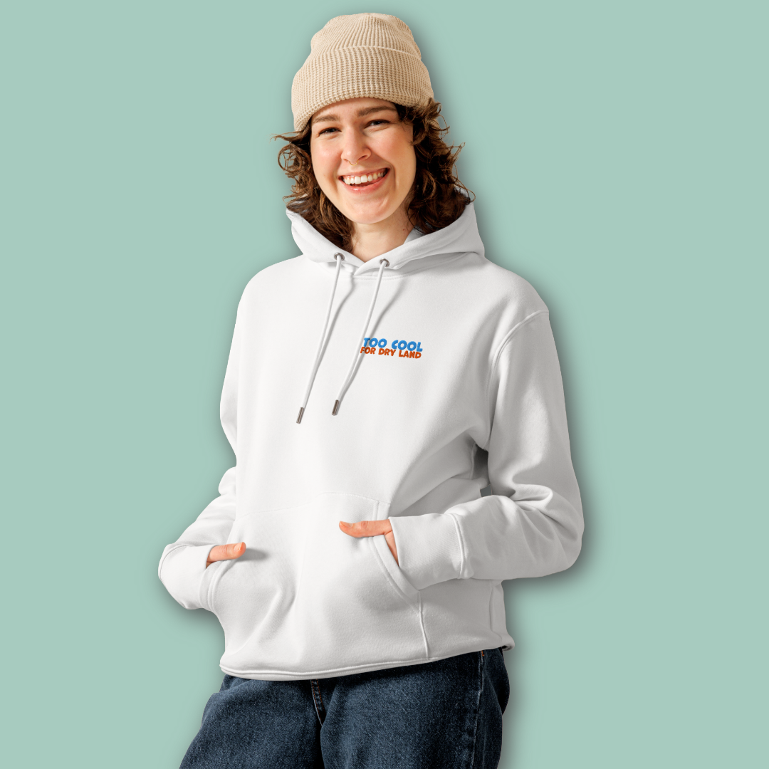 A woman wearing an organic hoodie in white with "Too Cool For Dry Land" embroidery in blue and orange, designed by Lane Line Threads for swimmer recovery and skin health.