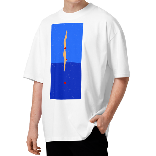 A man with curly brown hair wearing a white short-sleeve crewneck organic oversized t-shirt by Lane Line Threads featuring a graphic print of a minimalist figure diving into a blue water scene, displayed on a clean white background.