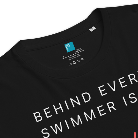 Black organic swim mom shirt with text 'BEHIND EVERY SWIMMER IS' on a white background