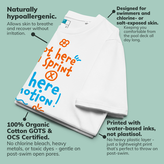White organic swim shirt with colorful text design on a light green background, featuring text about product features.