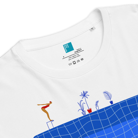 White t-shirt with a colorful graphic of a person on a surfboard and plants on a blue grid background.