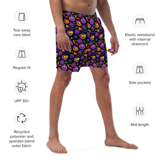 Person wearing colorful Halloween-themed organic swim trunks with product features listed on a white background.