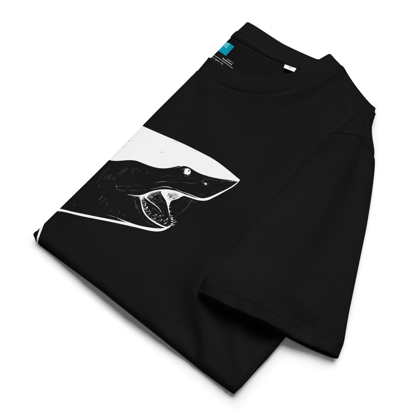 Black folded organic cotton t-shirt with a bold white shark graphic and vertical “Swim Mom” text—perfect for fierce, eco-conscious swim moms.