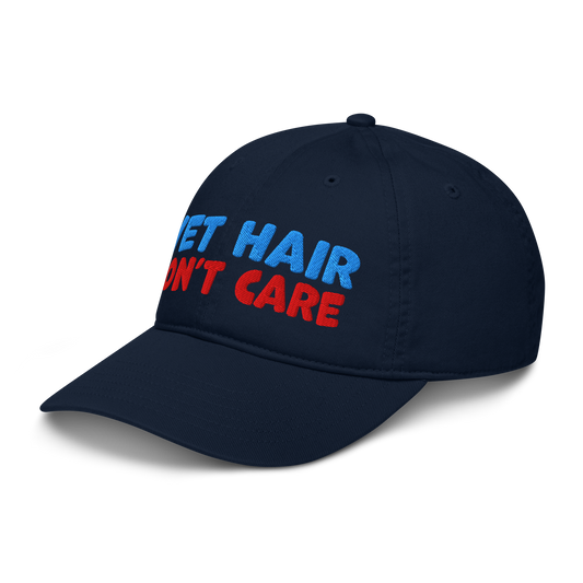 Navy blue cap with 'wet hair, don't care' text in red and blue on a white background