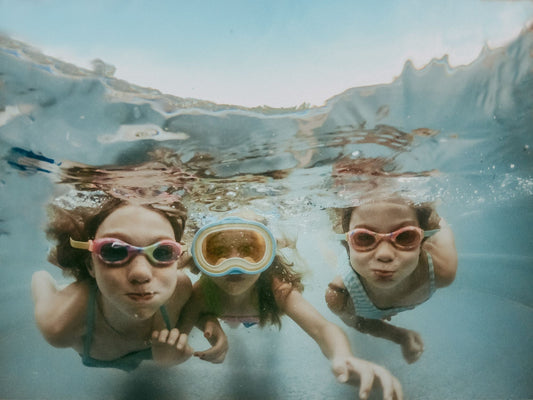 Children swimming underwater, showcasing joy and fun, related to post swim skin irritation.