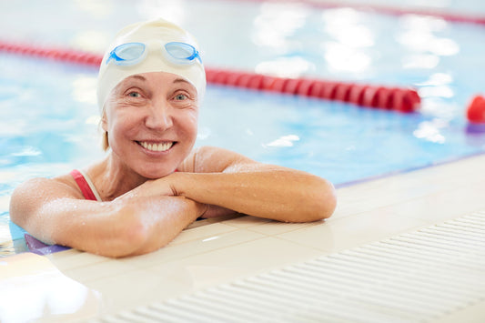 Happy masters swimmer enjoying recovery time by the pool, showcasing techniques for masters swimmer recovery.