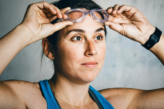 A swimmer adjusting her goggles, illustrating why swimmers skin needs different clothing.