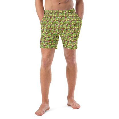 Person wearing green Halloween patterned recycled swim trunks on a white background