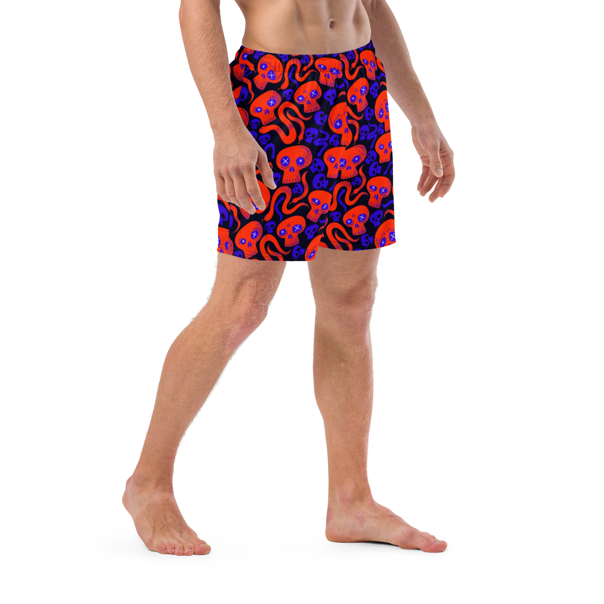 Person wearing a Halloween themed organic swim trunks with skulls and snakes pattern on transparent background