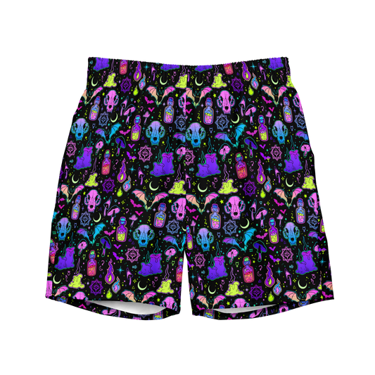 Colorful Halloween-themed organic swim trunks featuring skulls, moons, potions, and crystals on a black background; eco-friendly and designed for swimmers.