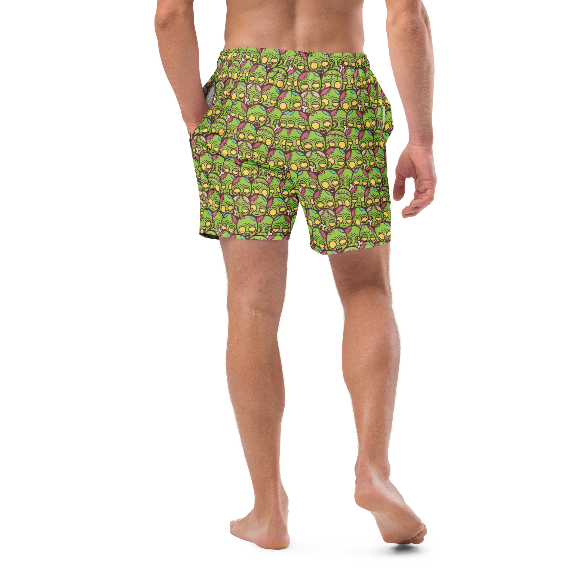 Person wearing green zombie patterned recycled swim trunks on a white background