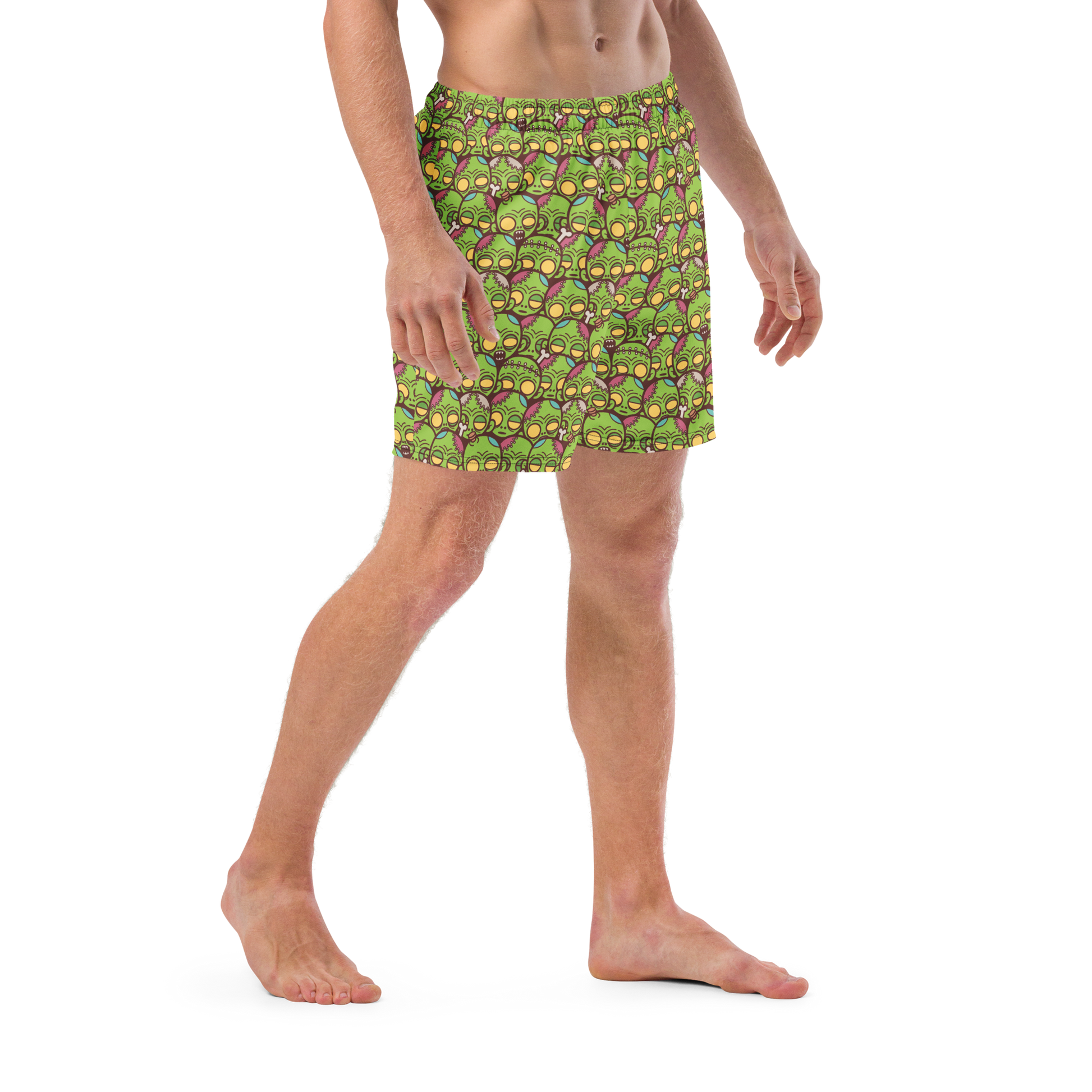 Person wearing a green zombie patterned recycled swim trunks on a transparent background