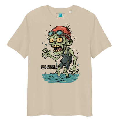 Beige funny Halloween swimming coach shirt with cartoon zombie coach in red swimming cap and goggles, text reads ‘Swim Coaching is Underrated’