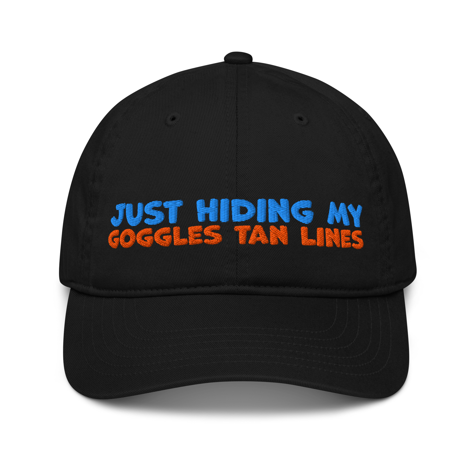 Black organic cotton baseball cap with "JUST HIDING MY GOGGLES TAN LINES" embroidered in blue and orange text.