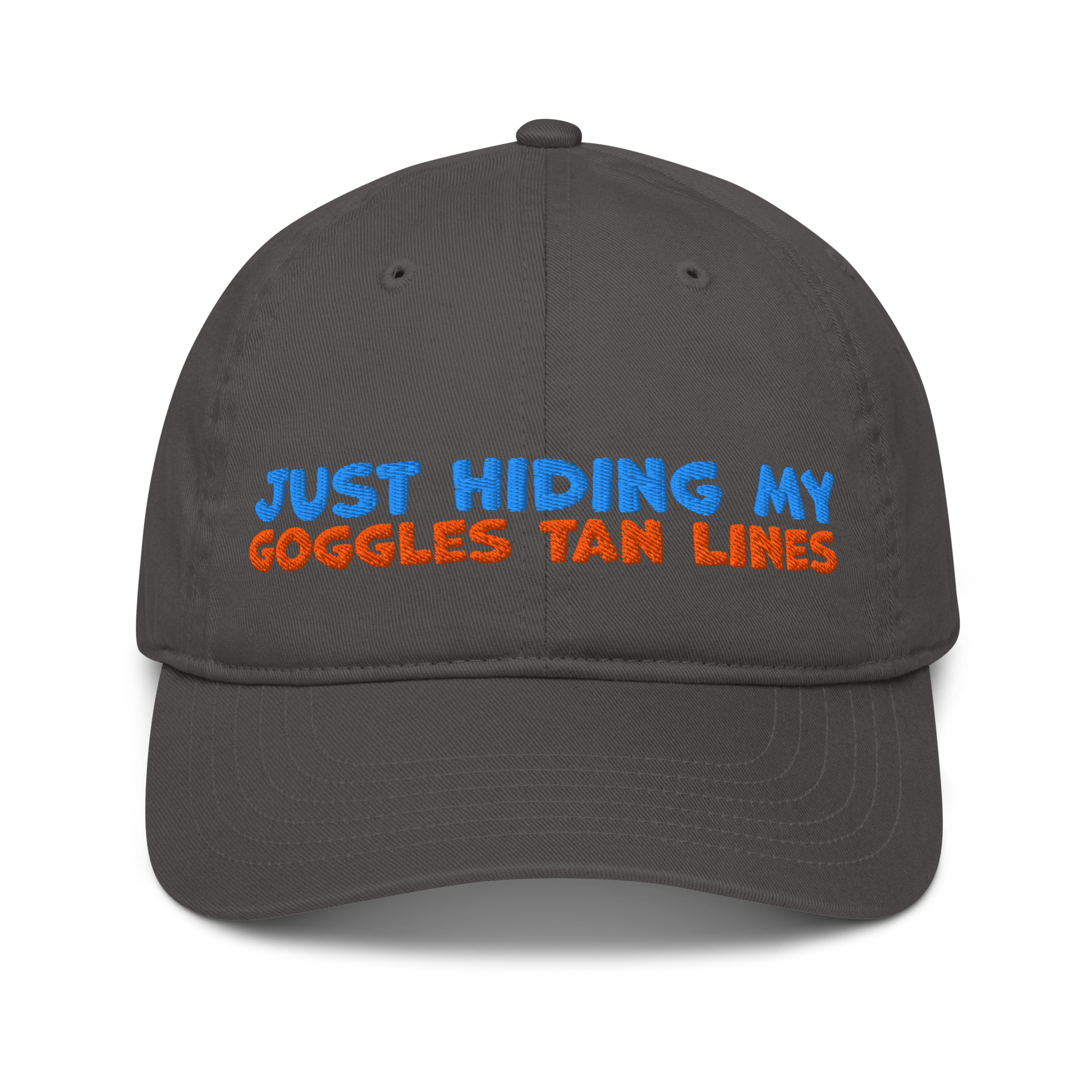 Charcoal organic cotton baseball cap with "JUST HIDING MY GOGGLES TAN LINES" embroidered in blue and orange text.