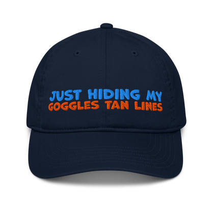 Navy blue organic cotton baseball cap for swimmers with "JUST HIDING MY GOGGLES TAN LINES" embroidered in blue and orange text.