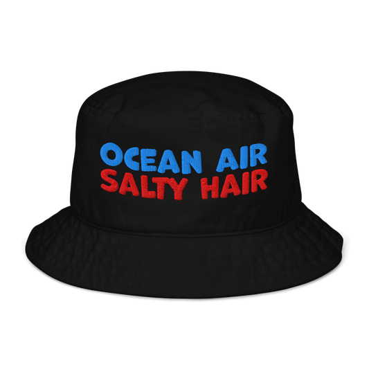 Black organic cotton bucket hat with bold embroidery that reads “Ocean Air Salty Hair” in blue and red. Eco-friendly, breathable, and biodegradable.