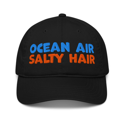 Black organic cotton baseball cap with "OCEAN AIR" in blue and "SALTY HAIR" in orange embroidered text