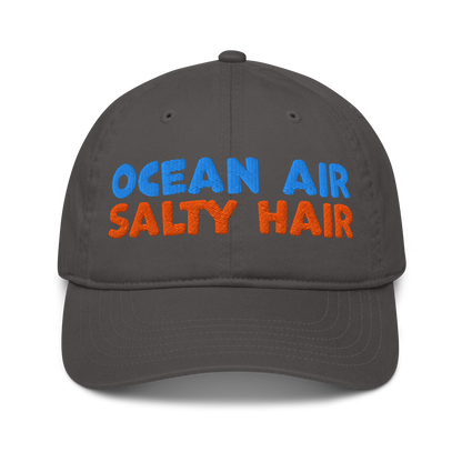 Charcoal organic cotton baseball cap with "OCEAN AIR" in blue and "SALTY HAIR" in orange embroidered text.
