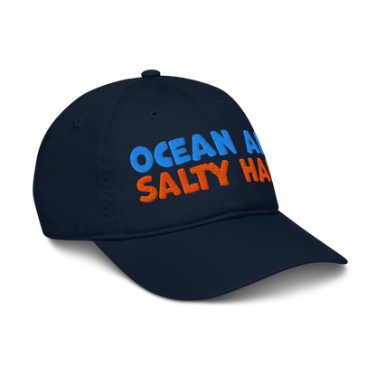 Navy blue cap with 'Ocean Air Salty Hair' text in blue and orange on a white background