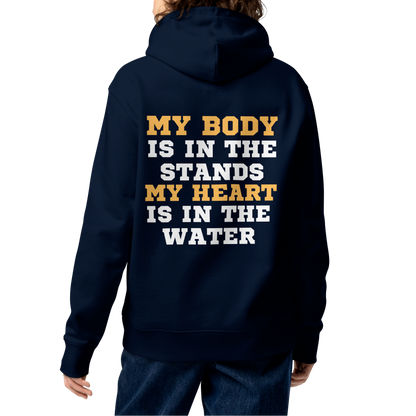 Person wearing a swim mom organic hoodie with bold gold and white varsity text reading "My Body Is In The Stands My Heart Is In The Water" — Lane Line Threads