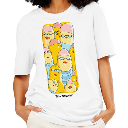 A woman modeling an organic cotton t-shirt white Lane Line Threads tee with colorful Sink or Swim cartoon swimmers in caps and goggles graphic, paired with cream wide-leg pants, against a plain white background.