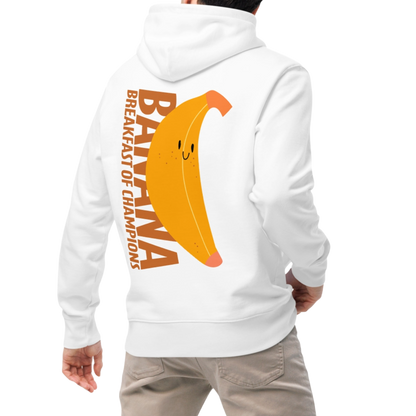 A person wearing an organic hoodie in white by Lane Line Threads with a smiling banana and "Banana Breakfast Champion" text graphic, made from GOTS and OCS certified organic cotton.
