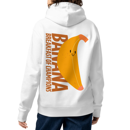 A person shown from the back wearing an organic hoodie in white by Lane Line Threads with a smiling banana and "Banana Breakfast Champion" text graphic, made from GOTS and OCS certified organic cotton.