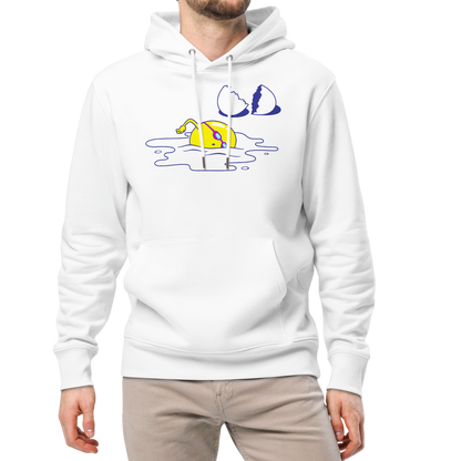 A man modeling an organic hoodie in white by Lane Line Threads featuring a graphic of a swimming yellow egg yolk with goggles and a cracked shell, paired with beige pants and white sneakers, against a plain white background.