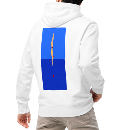 A man viewed from behind wearing an organic hoodie in white with blue back graphic showing a swimmer diving into water, designed by Lane Line Threads for post-swim comfort, paired with beige pants and white sneakers, against a plain white background.