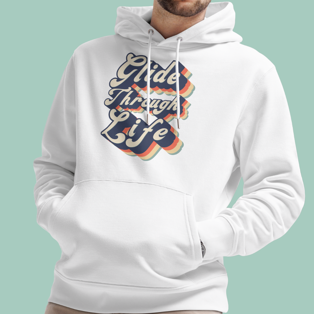 A white pullover organic hoodie worn by a model, featuring a retro-style graphic on the chest that reads 'Glide Through Life' in wavy navy, orange, and yellow lettering with a rainbow shadow effect. The background is a solid light mint green.