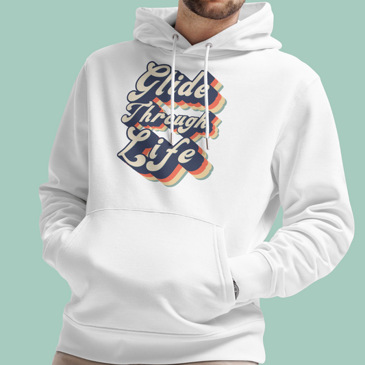 A white pullover organic hoodie worn by a model, featuring a retro-style graphic on the chest that reads 'Glide Through Life' in wavy navy, orange, and yellow lettering with a rainbow shadow effect. The background is a solid light mint green.