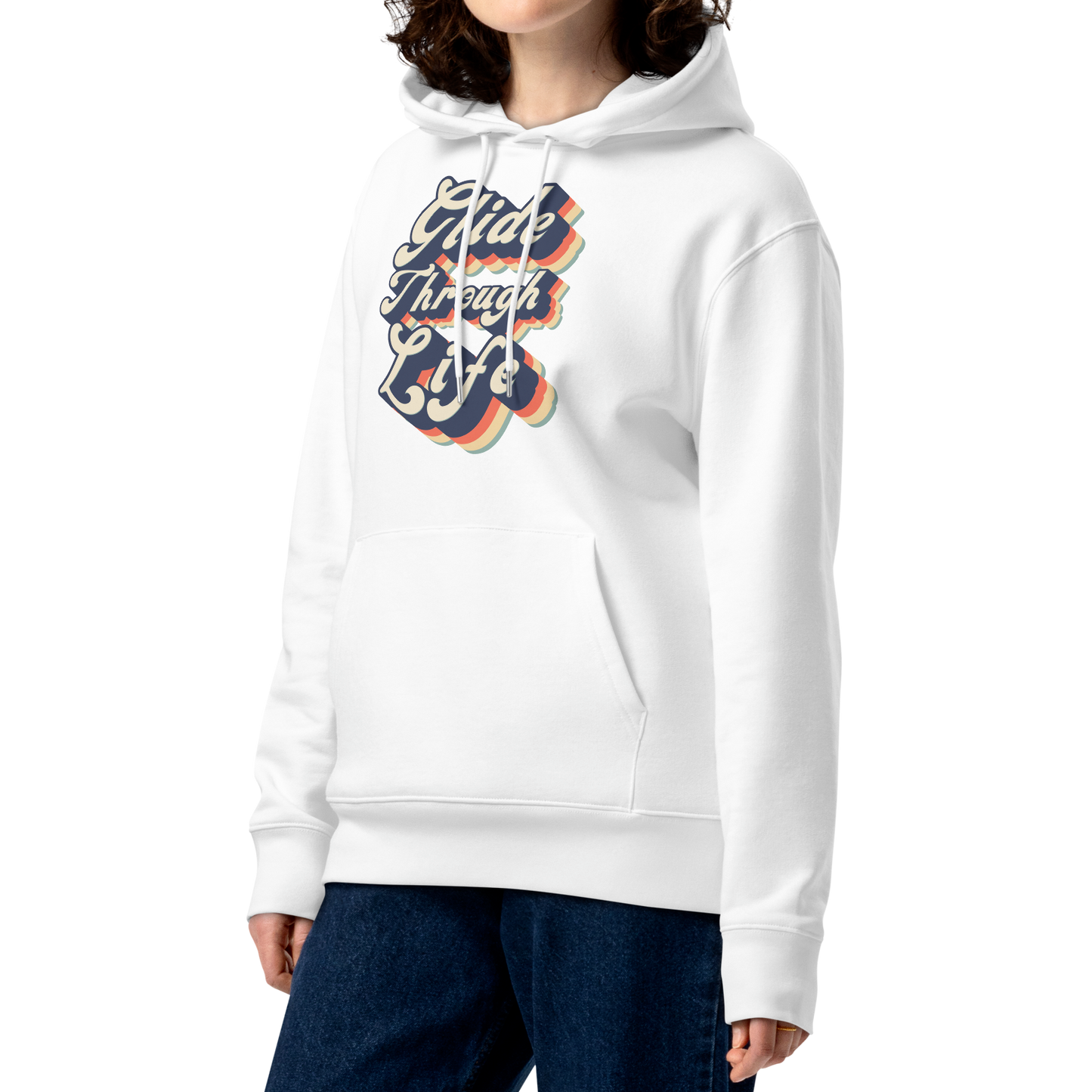 A woman with curly brown hair wearing an organic hoodie with "Glide Through Life" retro 3D typography on white GOTS and OCS certified cotton, designed for swimmer recovery, paired with dark blue jeans, set against a plain white background