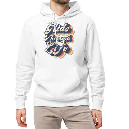 A man modeling an organic hoodie with "Glide Through Life" retro 3D typography on white GOTS and OCS certified cotton, designed for swimmer recovery, paired with beige pants and white sneakers, against a plain white background