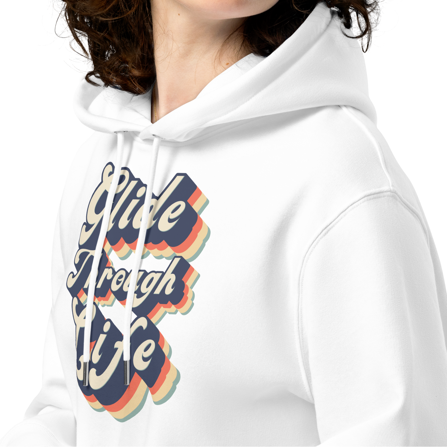 A woman with curly brown hair wearing an organic hoodie with "Glide Through Life" retro 3D typography on white GOTS and OCS certified cotton, designed for swimmer recovery