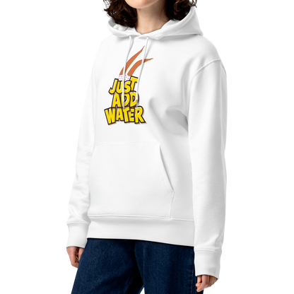 A woman with curly brown hair wearing an organic hoodie featuring a "Just Add Water" graphic with synchronized swimming legs on white GOTS certified organic cotton, paired with dark blue jeans, against a plain white background.